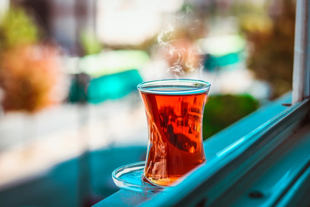 A steaming cup of Turkish tea on a windowsill with blurred background in Gaziantep.